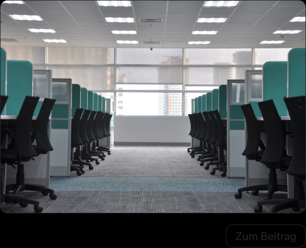 Modernes Büro mit Schreibtischreihen und großen Fenstern
